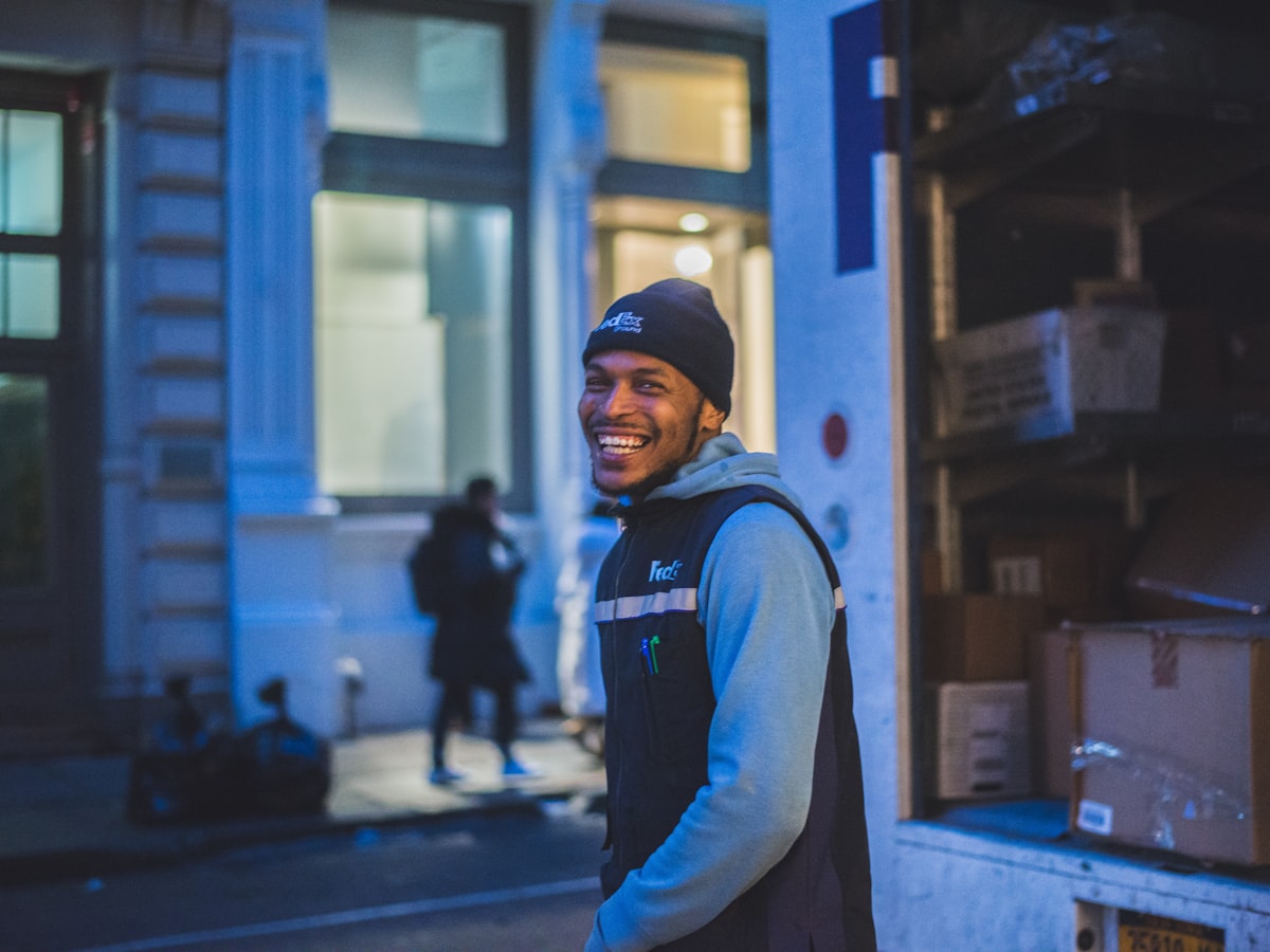 A StrongBox team member carrying a labelled storage box out of a Cape Town apartment building