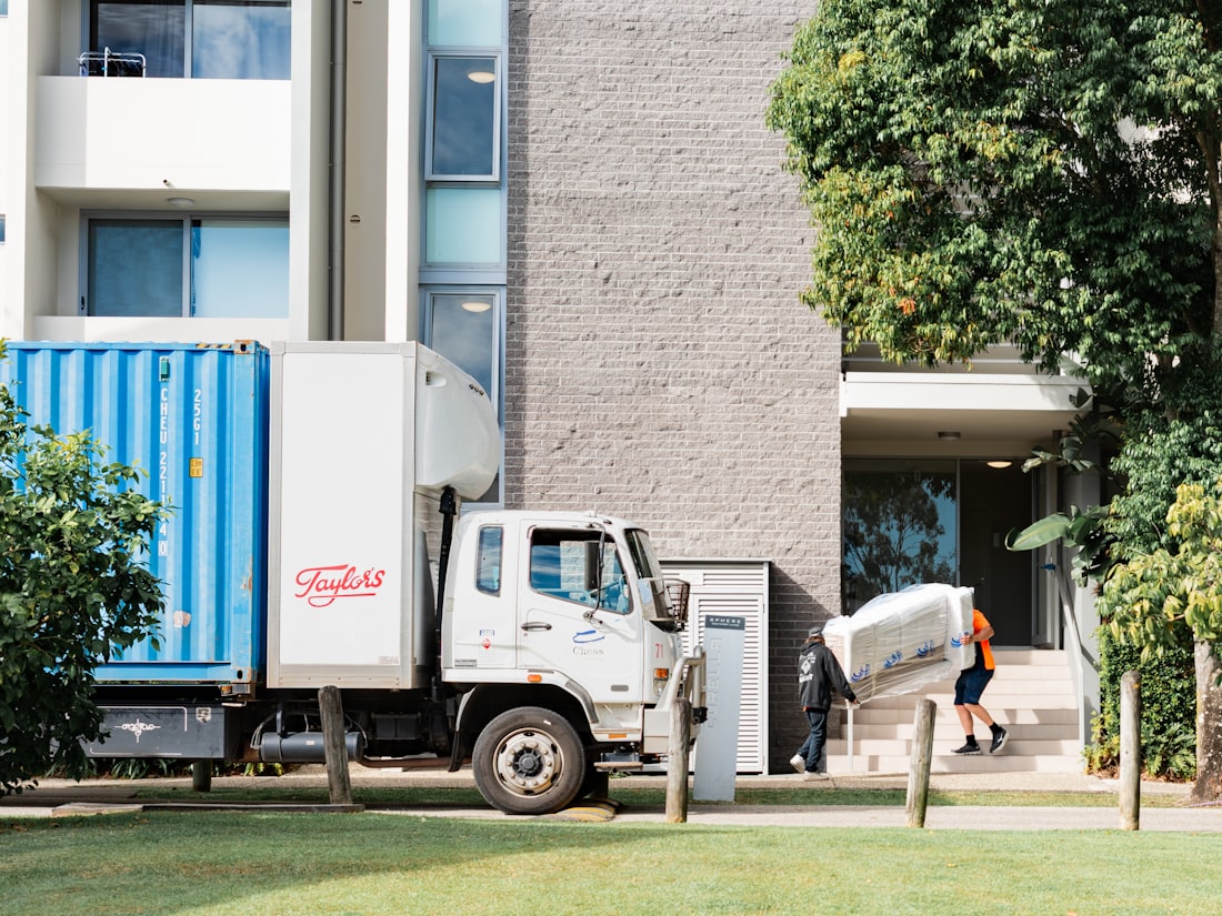 A bicycle, surfboard and armchair being loaded into a StrongBox van